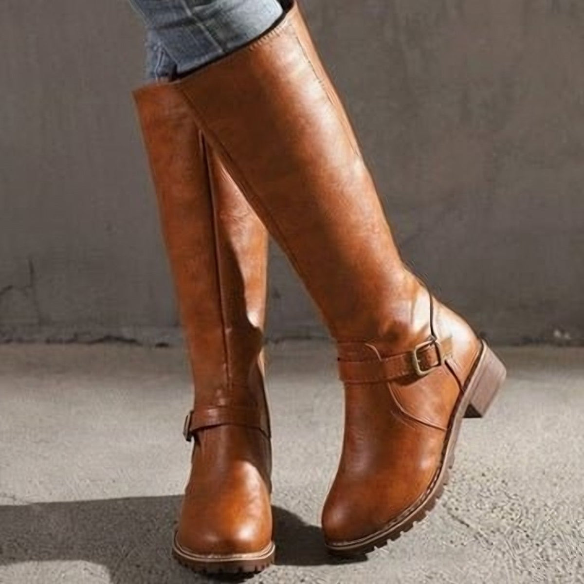 Tan knee-high riding boots with ankle buckles